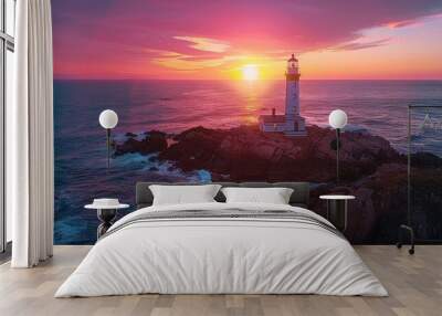 Dramatic drone timelapse footage captures a rotating lighthouse beam casting light across a rugged rocky coastline as the sky transitions from bright oranges to deep purples during a stunning sunset Wall mural