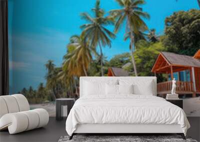 Bungalows of tropical beach with white sand, palm trees and turquoise waters. Wall mural