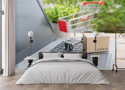 Boxes and trolley on a laptop keyboard. Ideas about online shopping, online shopping is a form a seller over the internet. - Image Wall mural