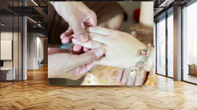 groom wears ring on bride's finger in wedding Thailand ceremony	
 Wall mural