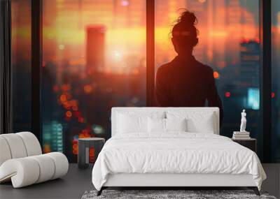 Ambitious woman standing in an office with a city view, representing success and determination Wall mural