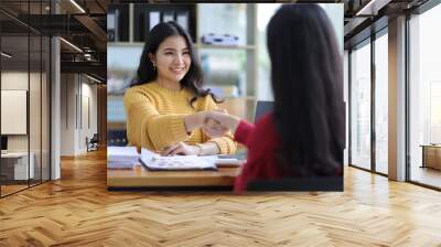 Happy businesswomen colleagues discussing in the office, Planning collaboration and participation of people in the organization, handshake, business cooperation. Wall mural