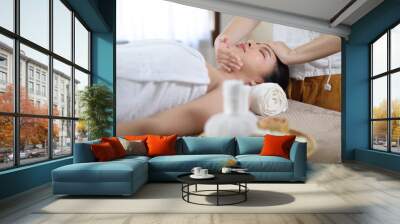 Relaxed Asian woman receiving beauty massage in spa salon. Wall mural