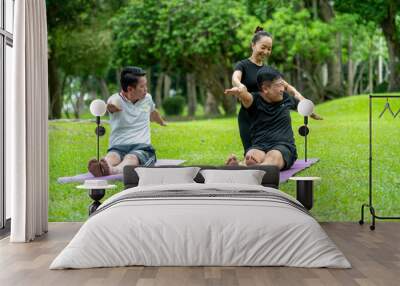 A man and two women are practicing yoga in a park Wall mural