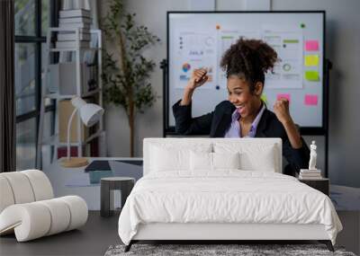 A woman is sitting at a desk with a laptop and a notebook Wall mural