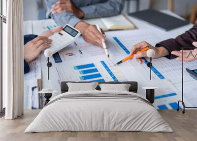 Business team analyzing financial data using calculator and documents Wall mural