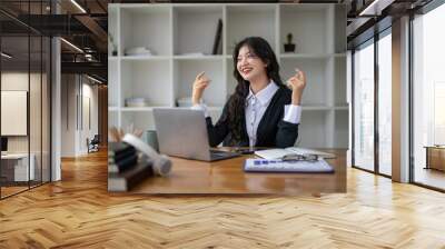 Freelance Asian woman enjoying video call on her laptop Remote work and communications. Wall mural