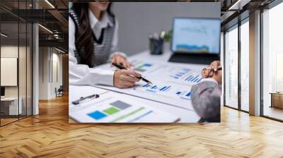 Two businesswomen analyzing financial charts and data on a report Wall mural