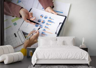 Two people are looking at a graph on a table Wall mural