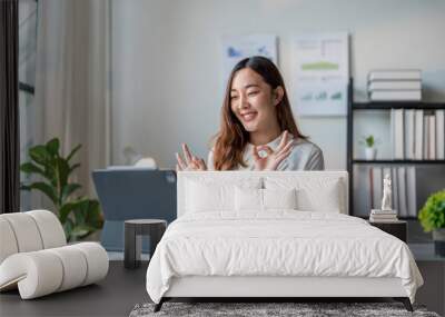 Young businesswoman making ok sign gesture during video call with tablet in office Wall mural