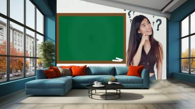 Young cute asian businesswoman thinking in the classroom  with question mark and blackboard mockup - .Education and curiosity concept Wall mural