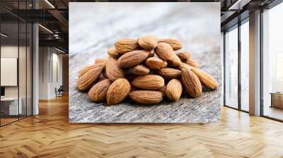 Almond or Prunus dulcis (Mill.) D.A.Webb seeds on and old wooden background. Wall mural