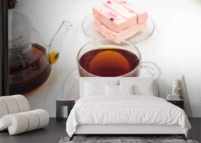 teapot and cup of black tea on a wooden table and pink fruit marshmallow Wall mural