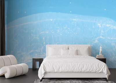 Blue water with ripples on the surface. Defocus blurred transparent blue colored clear calm water surface texture with splashes and bubbles. Water waves with shining pattern texture background. Wall mural