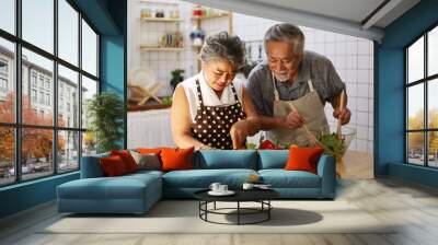 Happiness senior elderly couple having fun in kitchen with healthy food for working from home. COVID-19 Wall mural