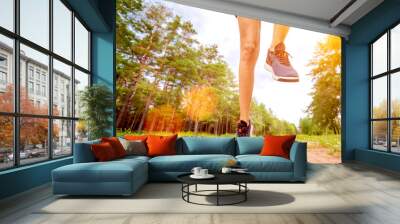 Closeup of athlete's feet running at the park. Fitness woman jogging outdoors. Exercising on forest path. Healthy, fitness, wellness lifestyle. Sport, cardio, workout concept Wall mural