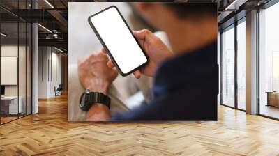 Over shoulder view of man using smartphone with blank screen for your advertise or text message. Wall mural