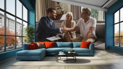 Active senior man shaking hands with real estate agent in living room Wall mural