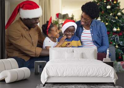 African american family siting on the sofa and using tablet Wall mural