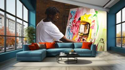 African american male painter at work painting on canvas in art studio Wall mural