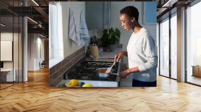 Beautiful woman cooking food in kitchen Wall mural