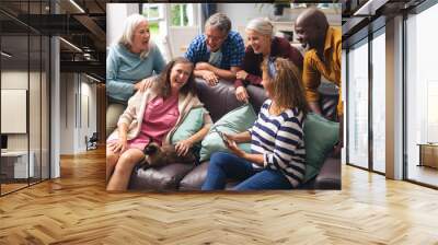 Cheerful multiracial senior male and female friends having fun at home Wall mural