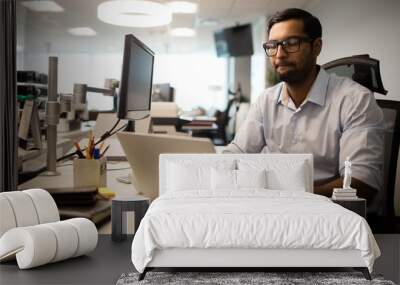 Concentrated businessman working on laptop in office Wall mural