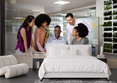 Diverse female and male businesspeople at desk talking and working in office Wall mural