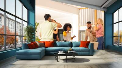 Friends drinking juice together in modern kitchen, enjoying casual gathering Wall mural