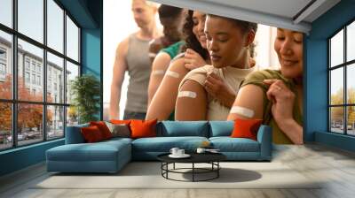 Group of diverse female and male friends showing plasters after vaccination Wall mural