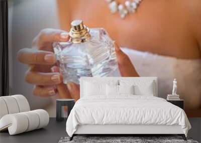 Midsection of smiling bride holding perfume sprayer while Wall mural