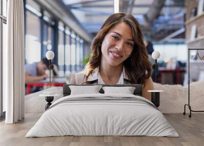 On video call, Smiling woman sitting on couch in modern office, hand on chest Wall mural