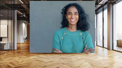 Portrait of happy biracial young female advisor with arms crossed by copy space on gray wall Wall mural