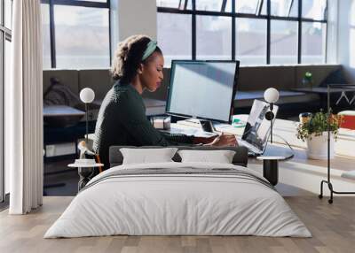 Side view of african american young businesswoman using laptop in office Wall mural