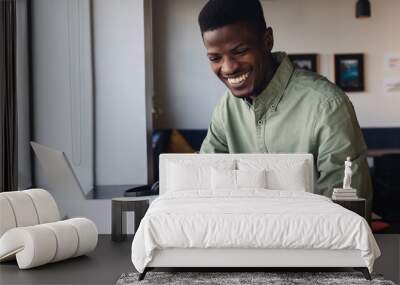 Smiling african american young businessman examining document in office Wall mural