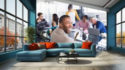 Smiling businessman sitting in meeting Wall mural