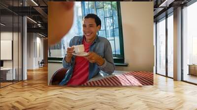 Smiling man with friend having coffee Wall mural