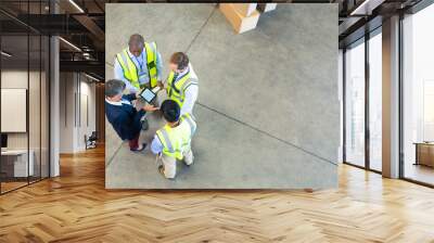 Warehouse staff discussing over digital tablet in warehouse Wall mural