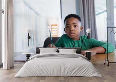 African american boy in online school class, writing in his notebook Wall mural