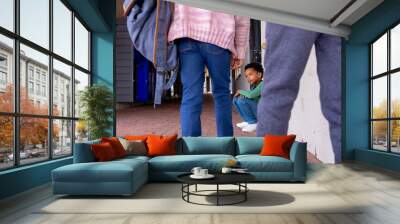 African American boy sits crouched between other children in school, looking sad Wall mural