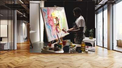 African american male painter at work painting on canvas in art studio Wall mural