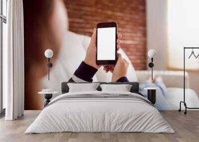 Asian woman on the couch using phone Wall mural