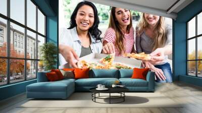 Beautiful happy female friends eating pizza Wall mural