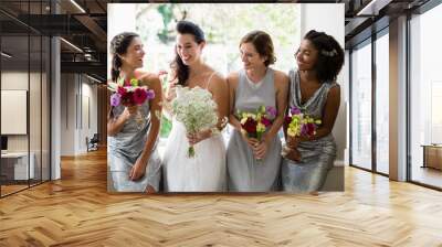 Bride and bridesmaids standing with bouquet Wall mural