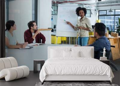 Business executives discussing over flip chart during meeting Wall mural