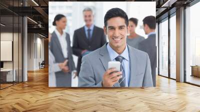 Businessman using mobile phone with colleagues behind Wall mural