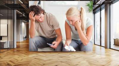 Calculating couple on a sofa Wall mural