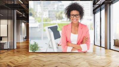 Casual female artist with arms crossed at bright office Wall mural