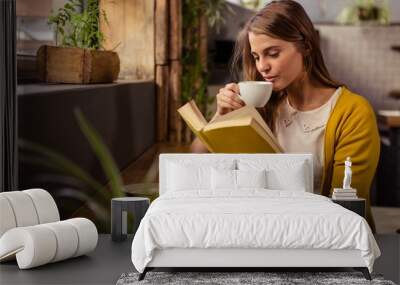 casual woman reading a book while drinking Wall mural