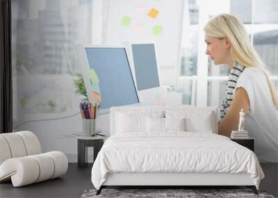 casual young woman using computer in office Wall mural